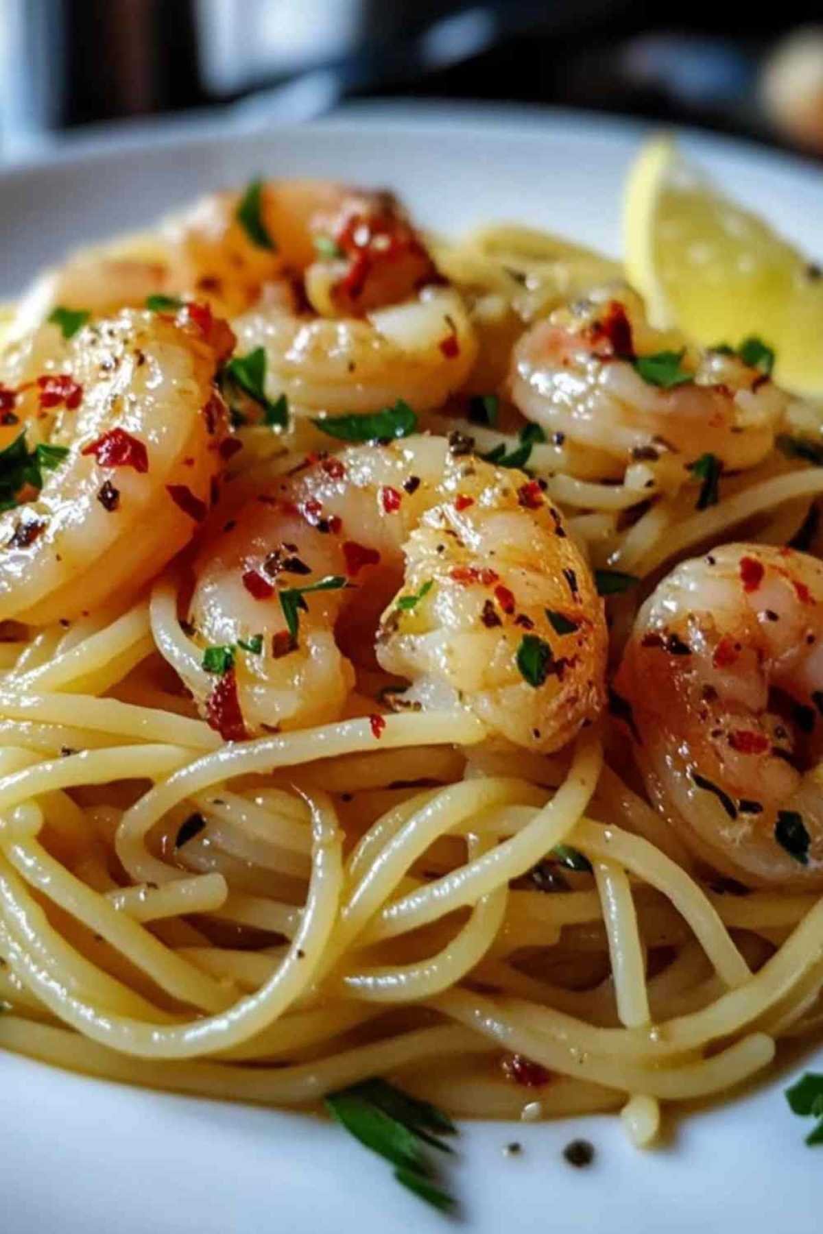 Spaghetti aux crevettes servis avec un verre de vin blanc