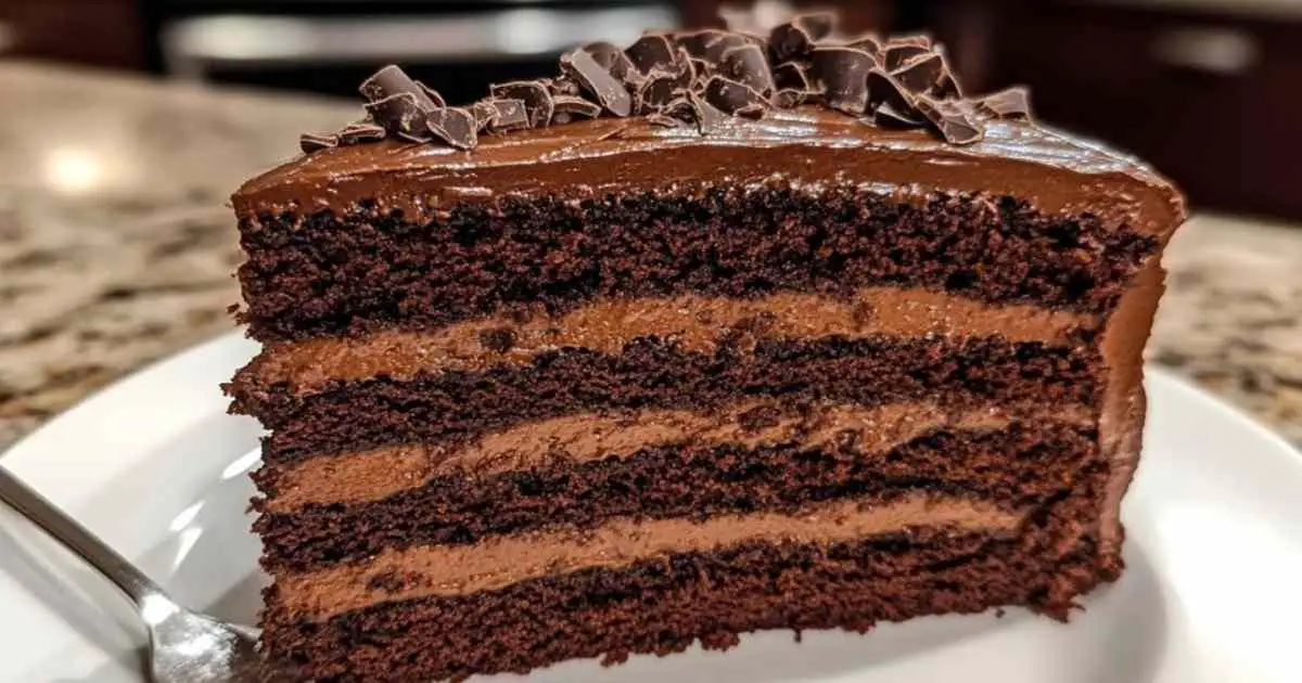 Tranche de cake au chocolat servie avec crème fouettée