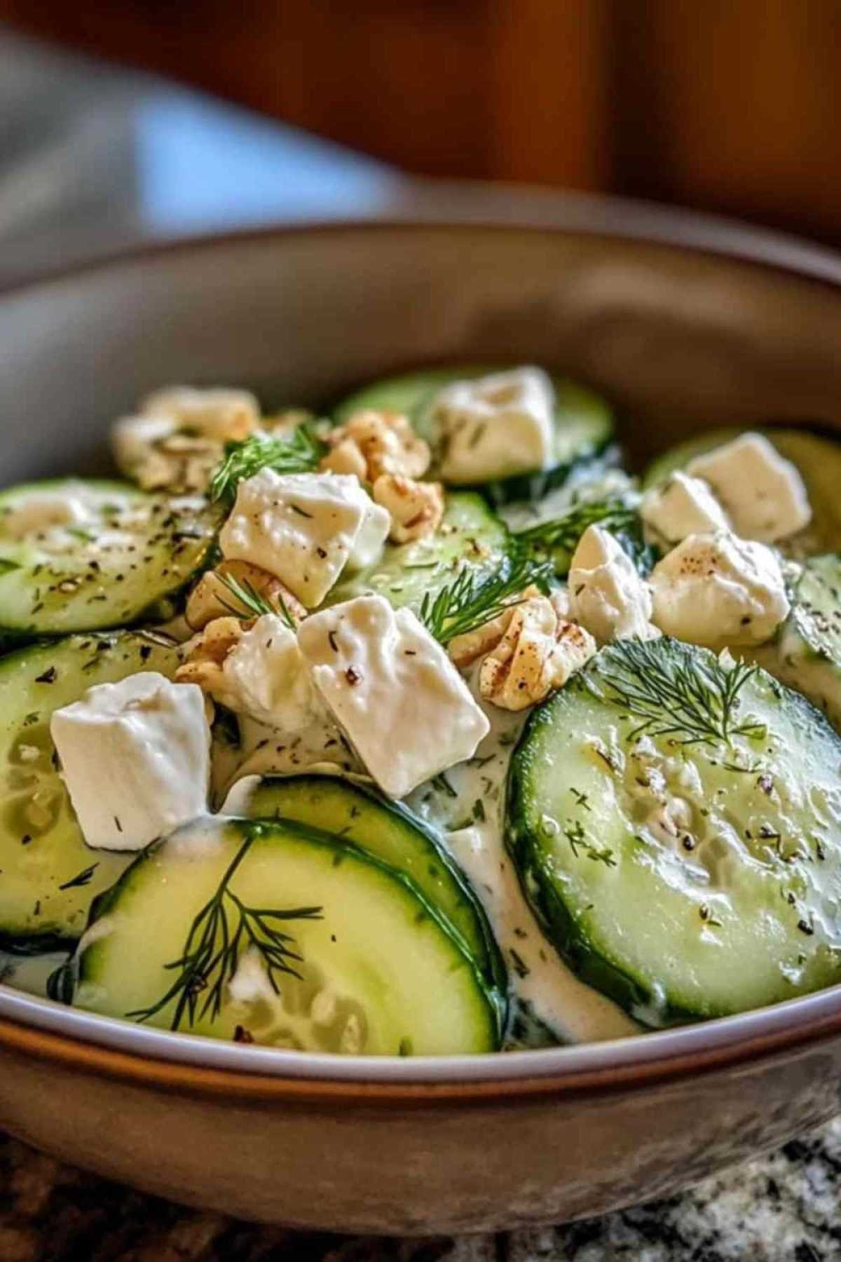 Salade de concombres crémeuse servie avec du pain pita et des olives