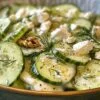 Salade crémeuse de concombres au fromage feta et aux noix dans un bol blanc