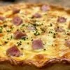 Quiche au jambon de poulet et fromage à raclette dorée sortant du four