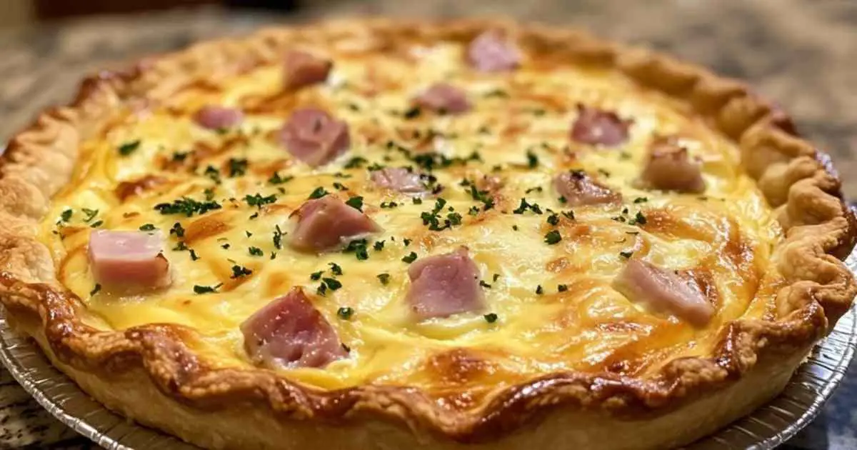 Quiche au jambon de poulet et fromage à raclette dorée sortant du four