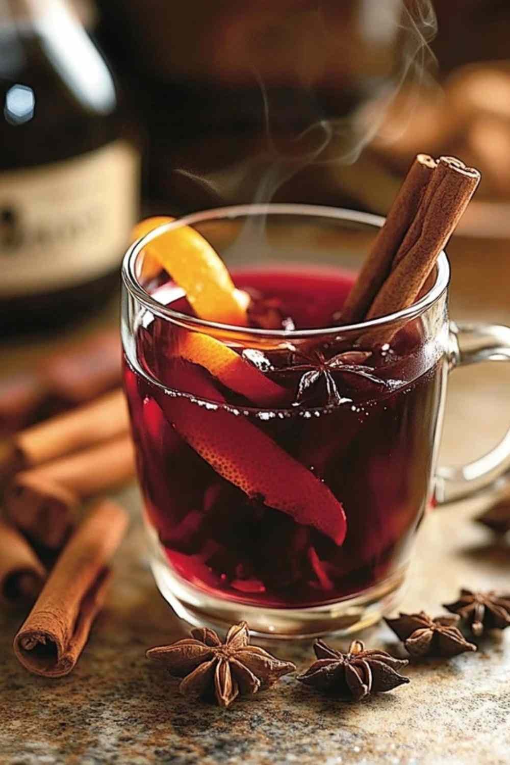 Vin chaud épicé servi dans un mug avec bâton de cannelle et rondelle d’orange