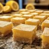 Carrés au citron saupoudrés de sucre glace sur un plat de service