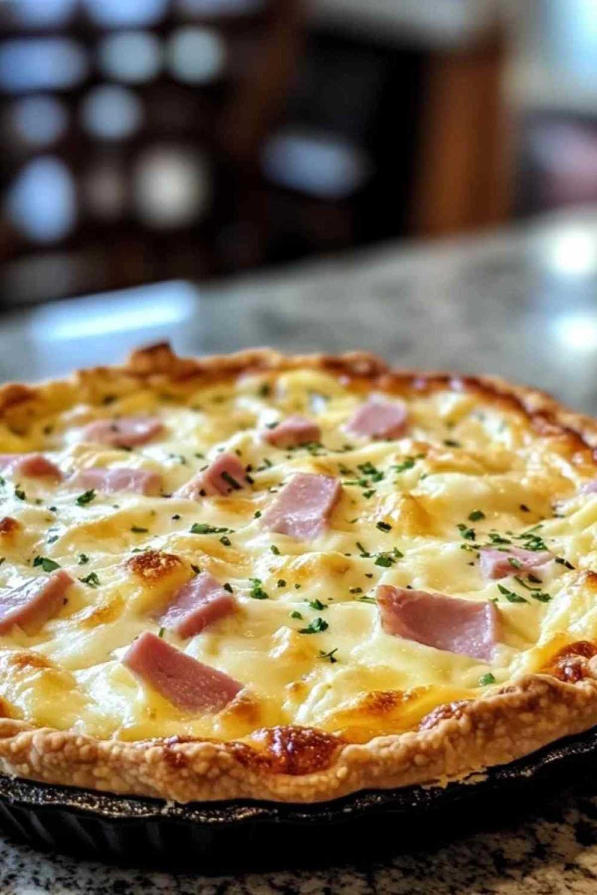 Part de quiche au jambon de poulet et raclette servie dans une assiette