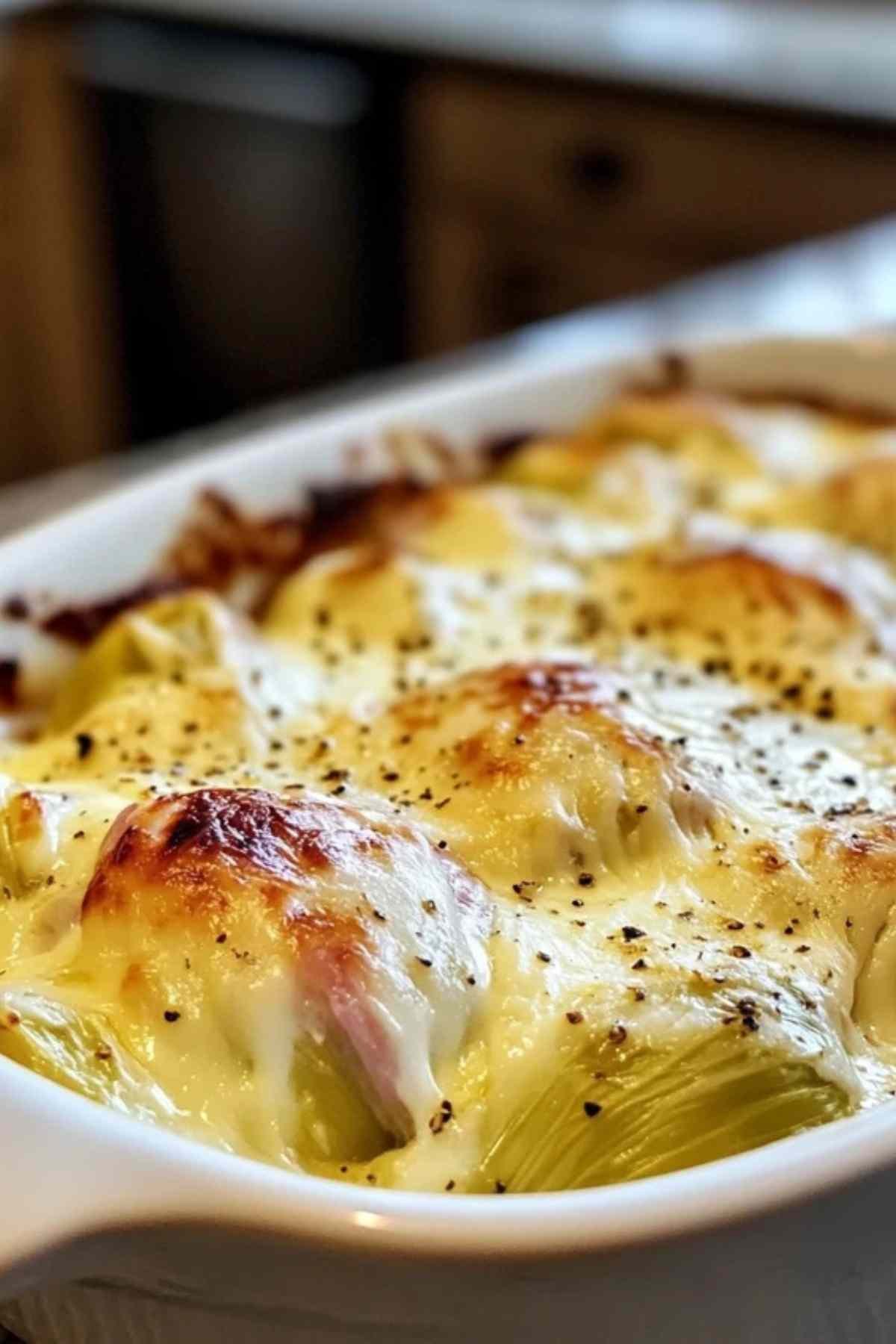 Endives enroulées dans du jambon disposées dans un plat à gratin