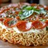 Part de pizza ramen avec filaments de fromage et garnitures colorées